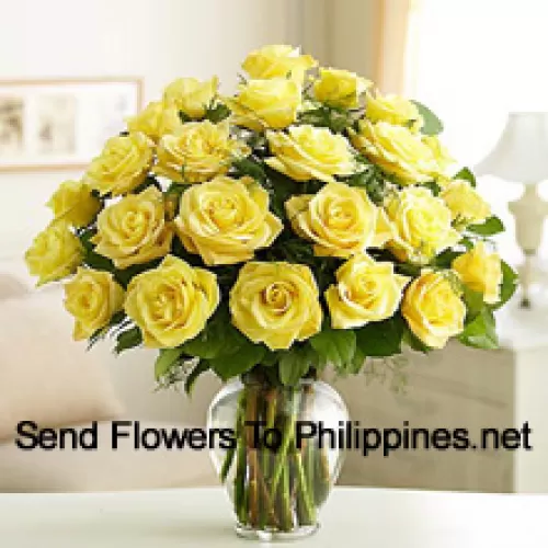 24 жёлтых розы с папоротниками в стеклянной вазе