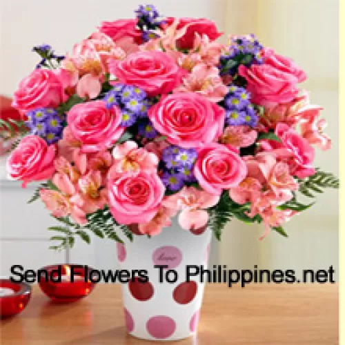 Rosas cor-de-rosa, orquídeas cor-de-rosa e diversas flores roxas dispostas lindamente em um vaso de vidro