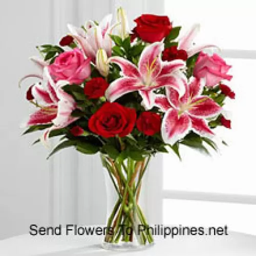 玻璃花瓶里的红色和粉色玫瑰花，粉色百合花和季节性填充物
